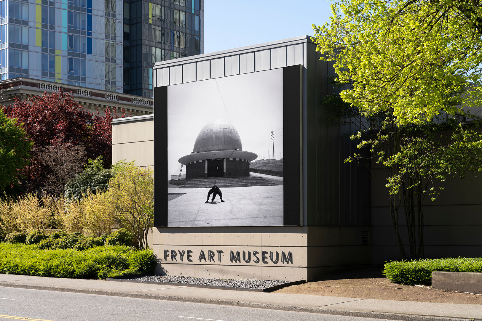 A large black and white photographic banner install on the outside of a building above the text 'Frye Art Museum'