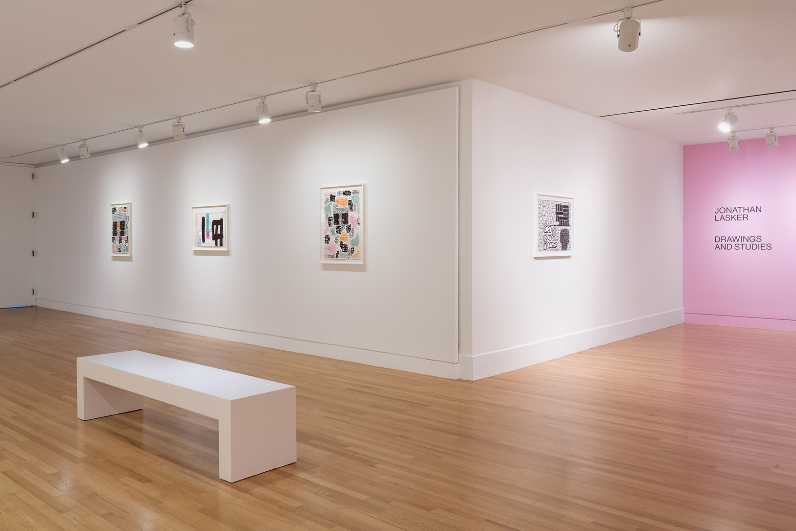 A gallery space with small, framed artworks on white walls