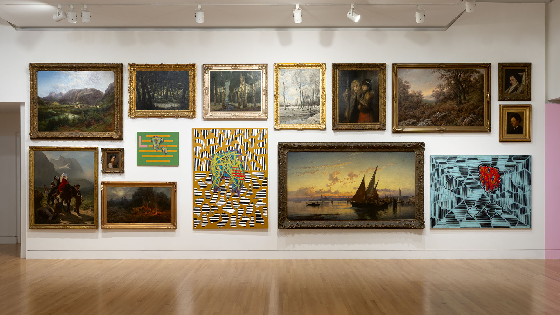 A large room with a mix of traditional and abstract paintings hung densly on the walls