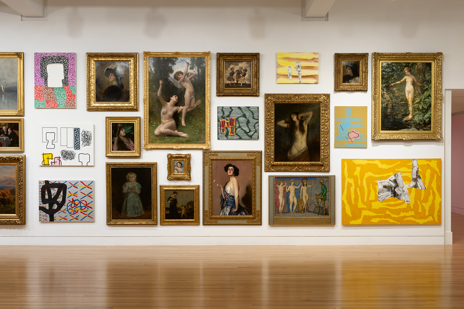 A large room with a mix of traditional and abstract paintings hung densly on the walls