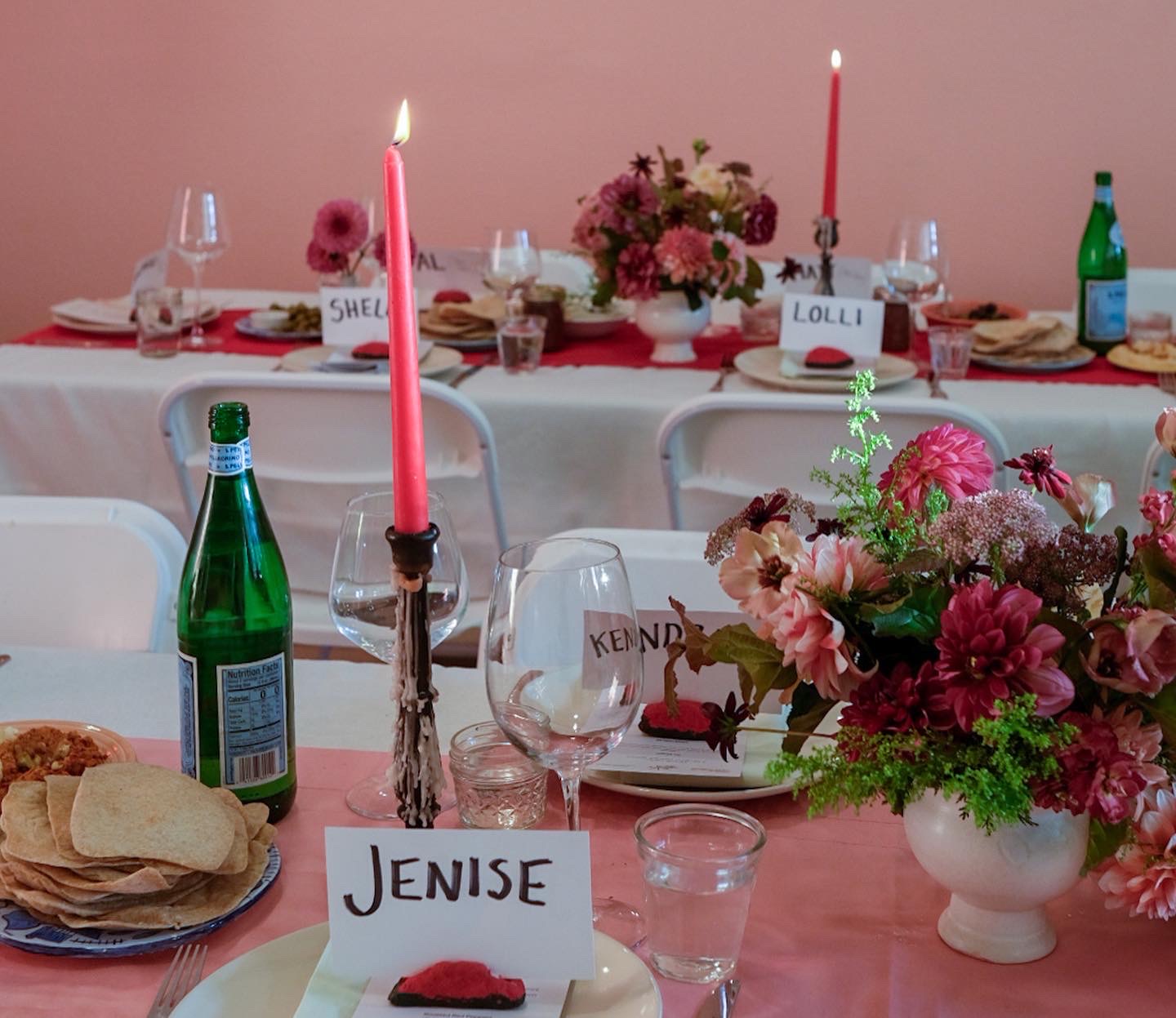 Table settings with flowers, candles, and name tags on two long tables