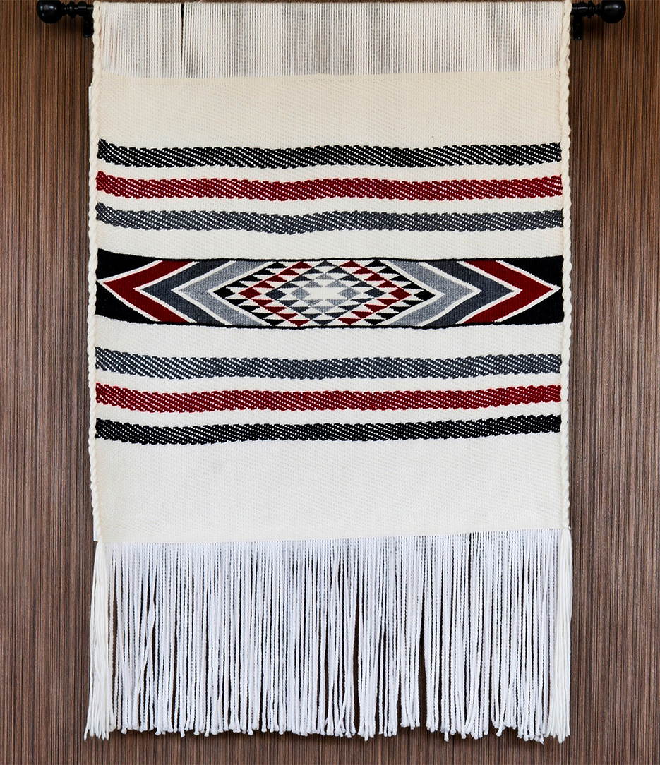 A hanging tapestry in white with black and red accents