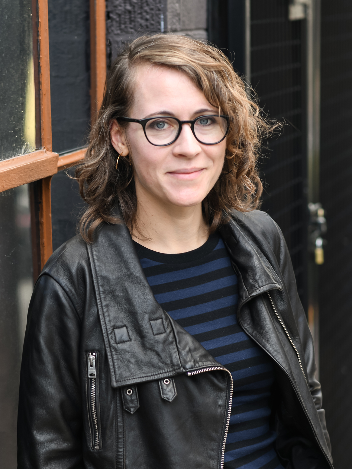 Photo of Erin Langner, a woman with shoulder-length brown hair and glasses, smiling and looking at the camera