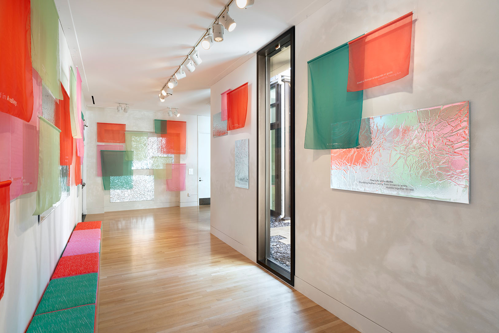 A well lit hallway with walls covered in colorful fabrics and reflective panels