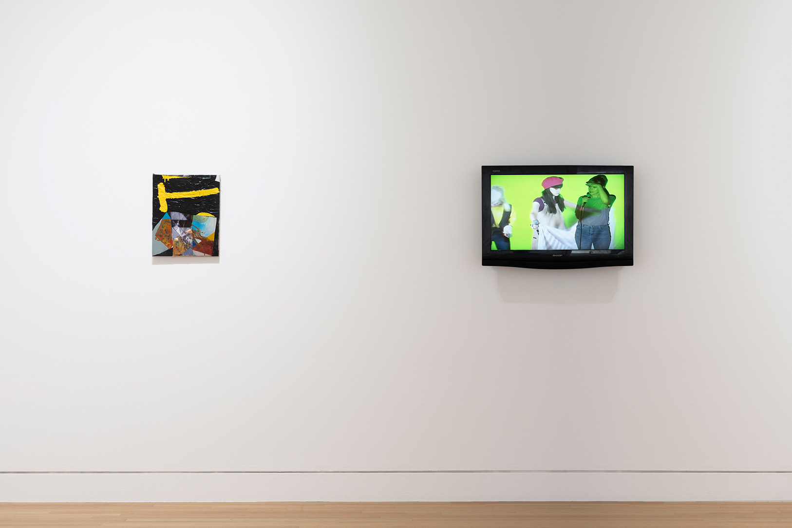 A view of two artworks hanging on a white wall in a gallery space