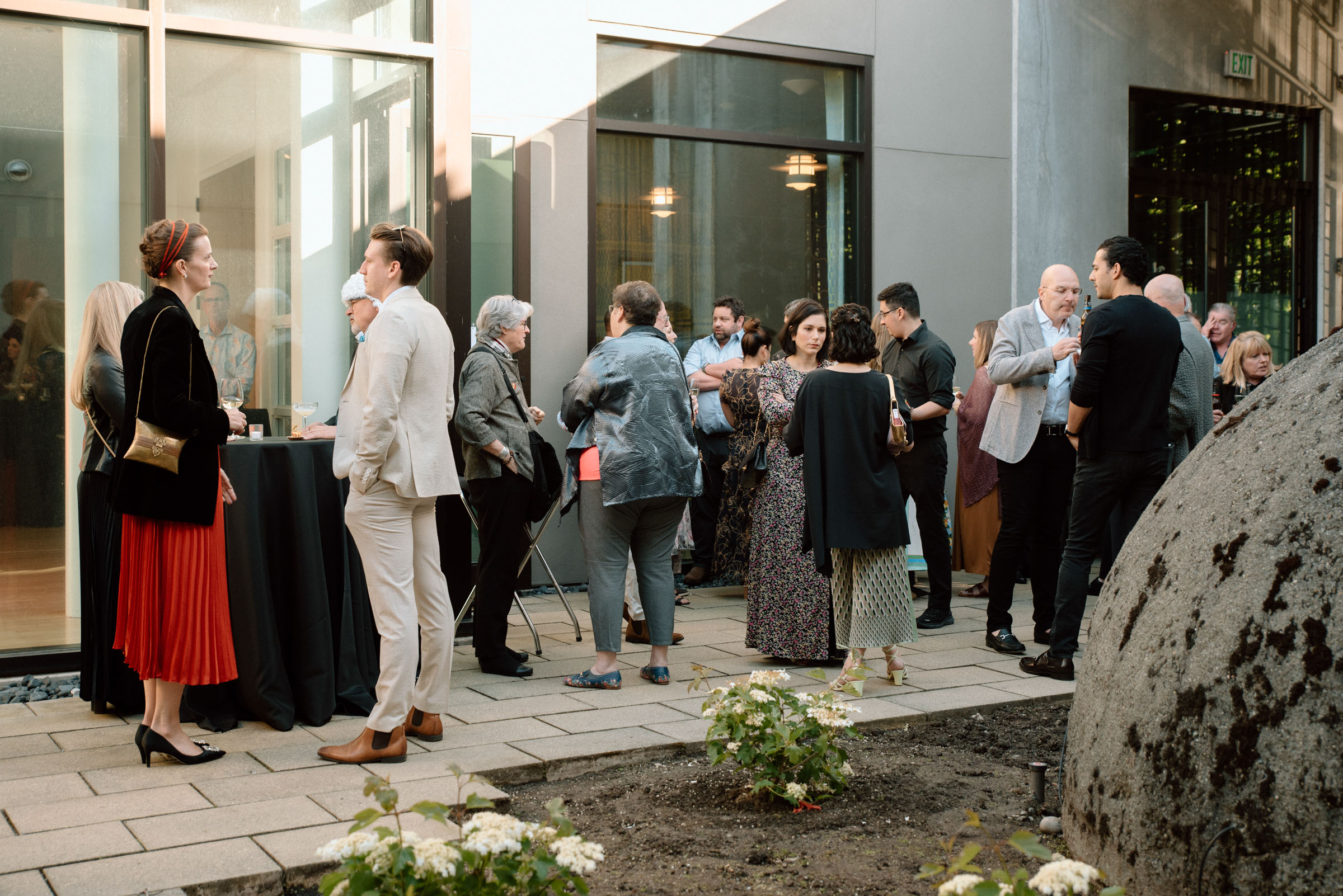 People gathered outside in a sunny courtyard