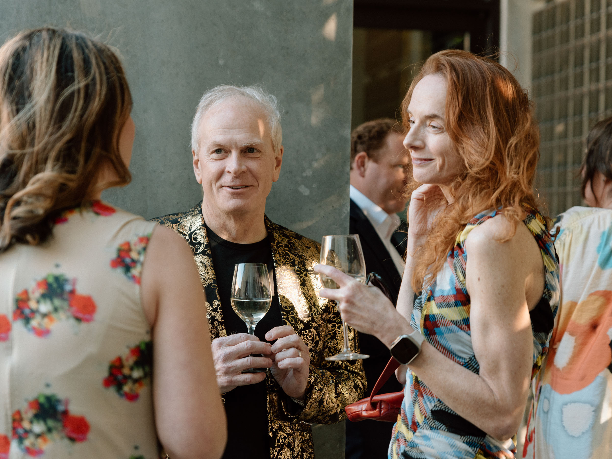 People standing outside and chatting while holding drinks