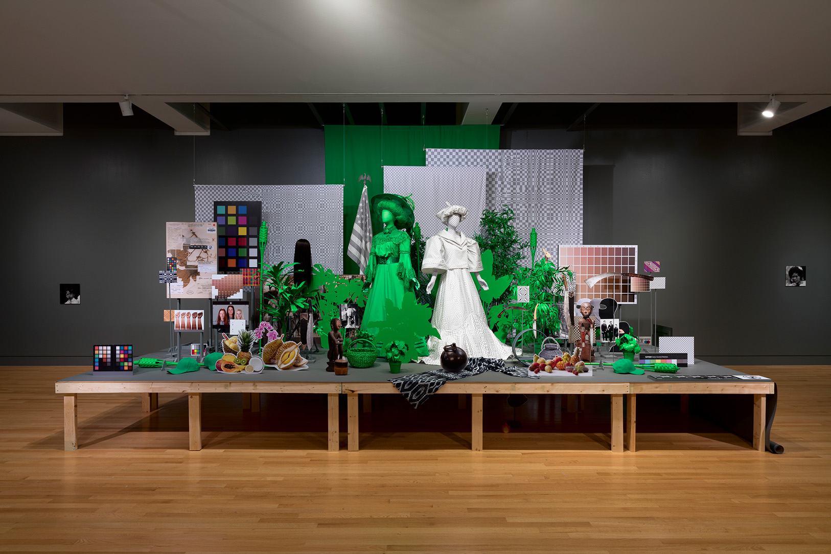 An artwork installation of a large number of figures and physical materials on a platform