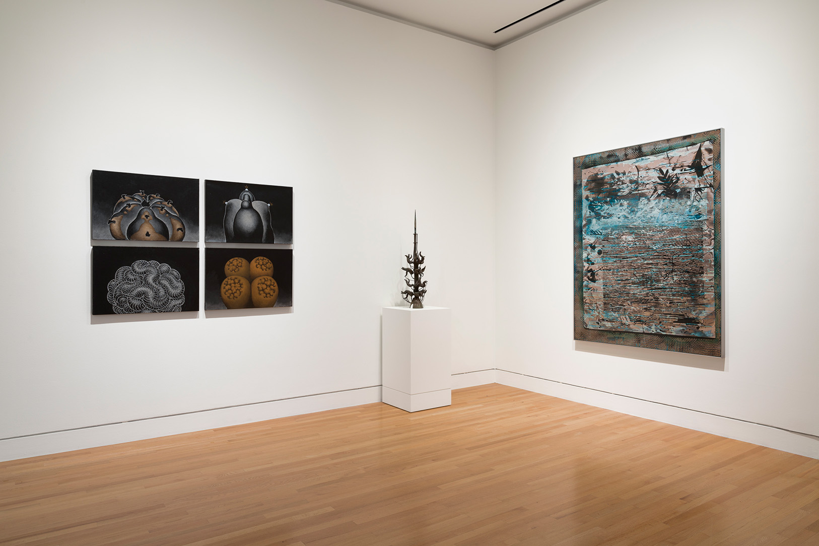 Installation image of four paintings grouped on the left wall, a sculpture on a pedestal, and a single painting on a right wall