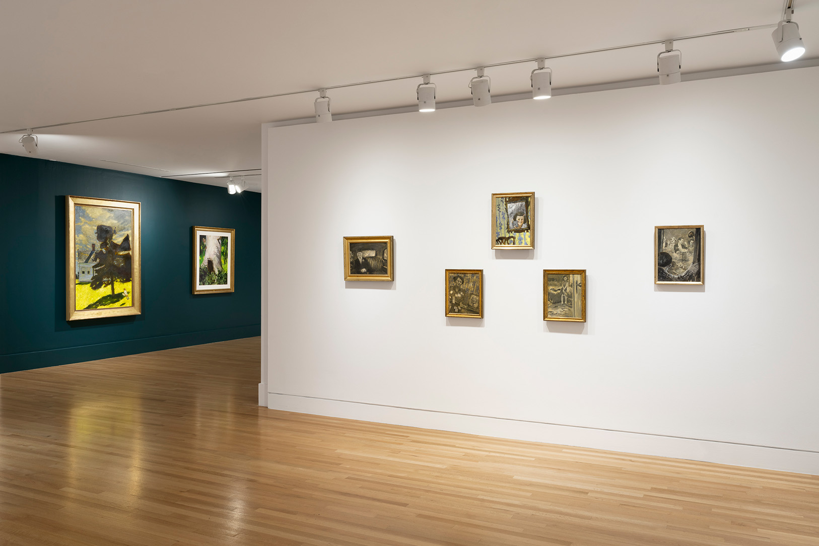 A view of paintings in a gallery space. On the right are a small series arranged in a pattern, and on the left in the background are two hung side by side
