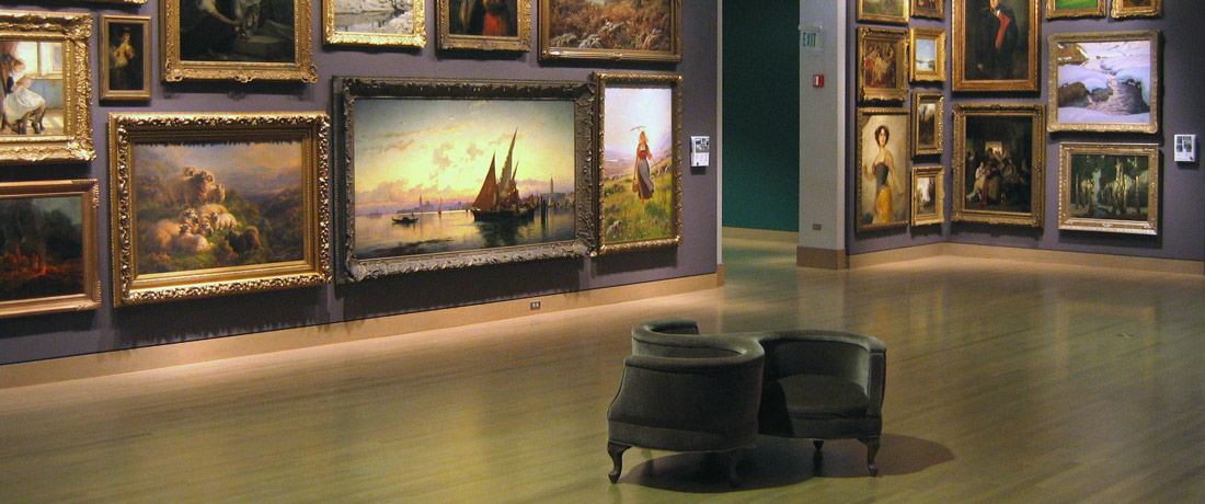 A circular chair in a large room whose walls are covered in oil paintings
