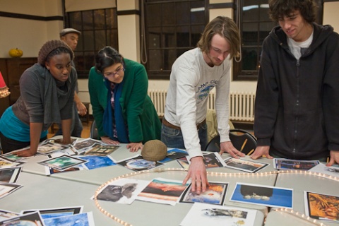 People standing around a table and looking at printed images