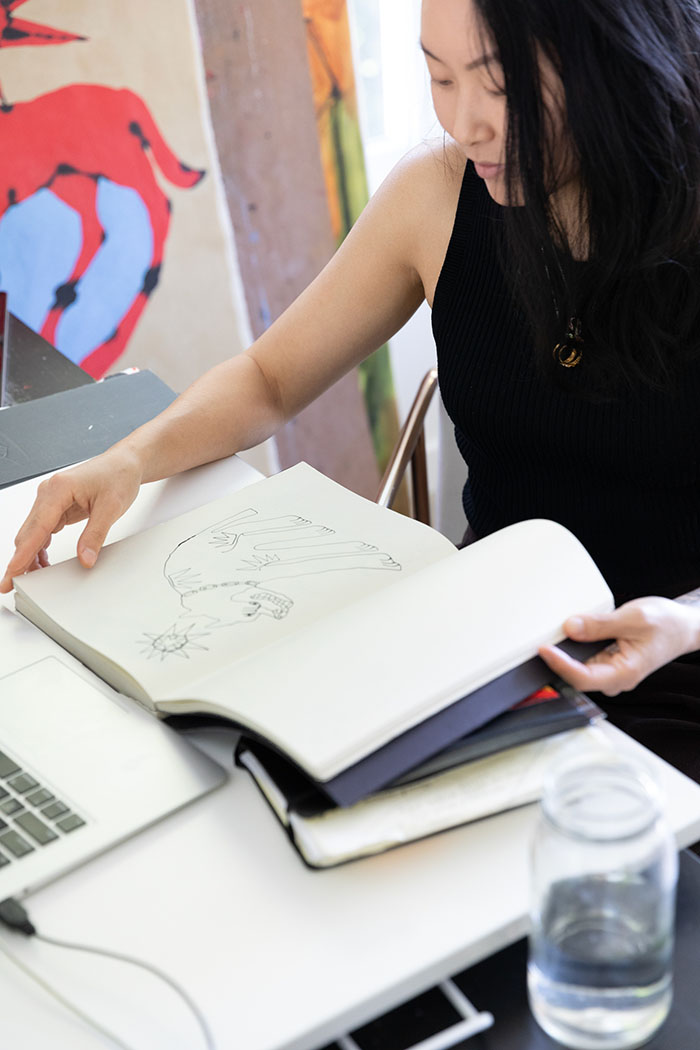 A person looking through a notebook with drawings
