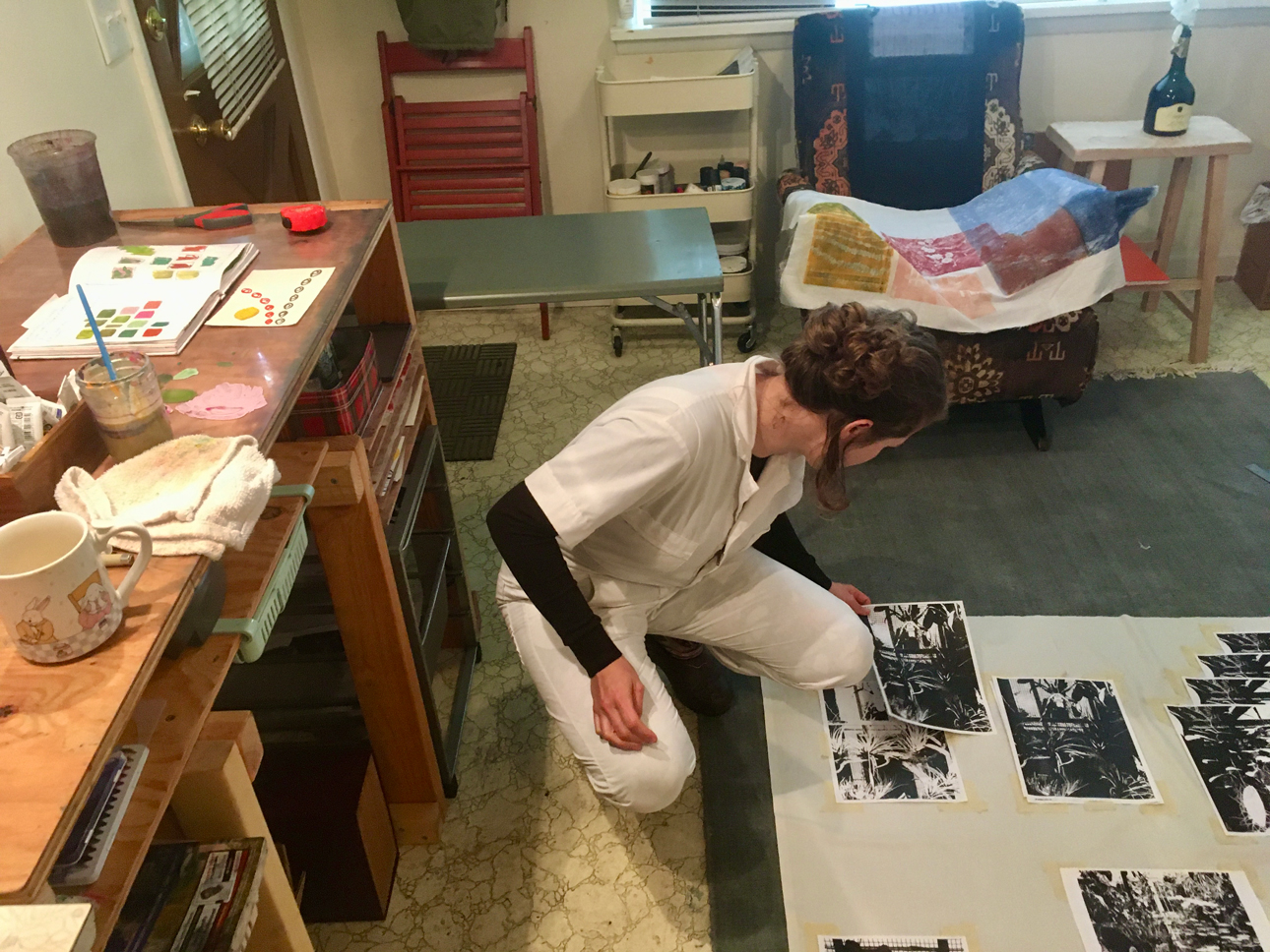 Photo of Shannon Bodrogi laying out a photocopy composition on the floor in their studio