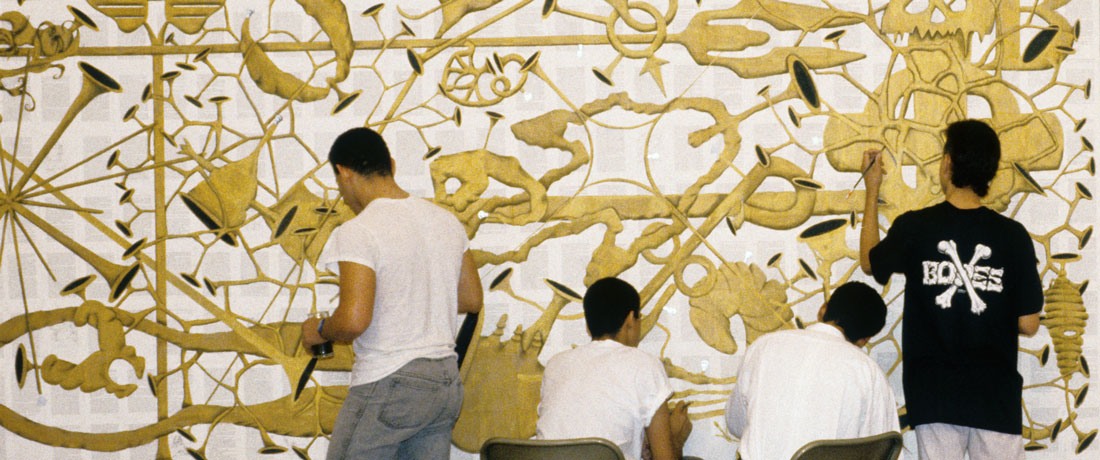 People painting different parts of a large mural