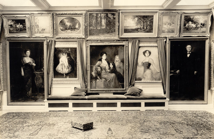 A photo of paintings hung salon style in a home