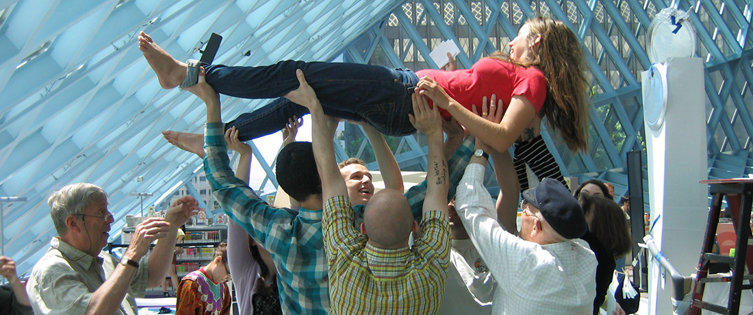 People holding up a single individual as part of a performance