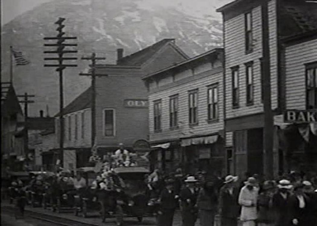 A still from a film of people in a street in a town in Alaska in the early 20th century
