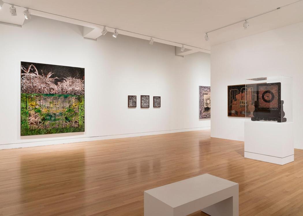 Artworks on the walls and on a pedestal in a museum gallery