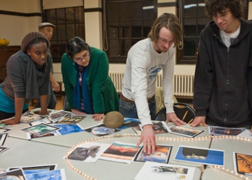 People standing around a table and looking at printed images