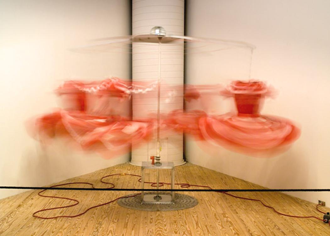 A long exposure photo of a dress being moved by machinery