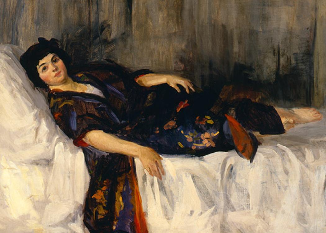 A woman lounging on a bed wearing a blue kimono