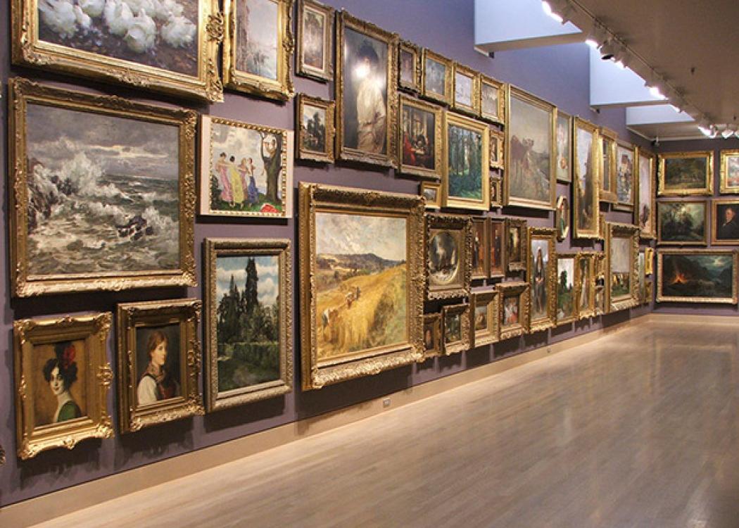 A museum wall covered in paintings